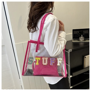 Detail view of transparent PVC tote with pink inner bag and embroidered STUFF lettering