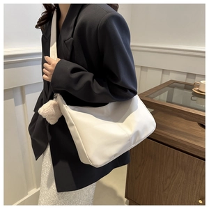 Detail of white PU leather hobo bag with vertical stitching and plush charm