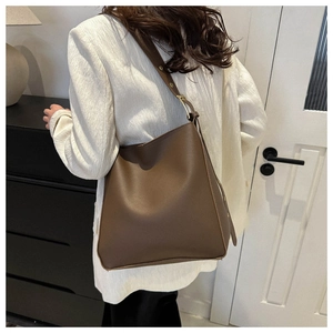 Detail view of brown PU leather shoulder bag with adjustable gold buckle and wide strap
