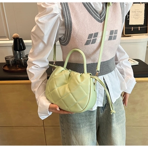 Detail of light green PU leather crossbody bag with quilted diamond pattern and drawstring