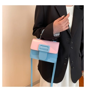 Close-up of pink and blue contrast PU leather handbag with decorative square buckle