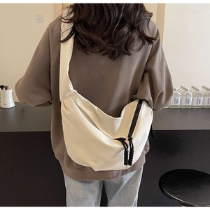Detailed back view of a white crescent crossbody bag with woven rope zipper detail