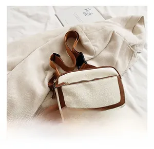 Detail showing the white lychee grain leather texture and brown trim of the stylish bag