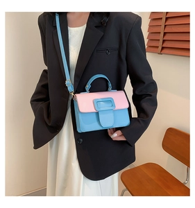 Detail of a color-block mini bag with pink flap and blue body featuring a square buckle