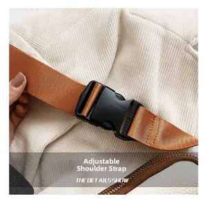 Detail view of adjustable orange-brown shoulder strap with buckle and white fabric texture