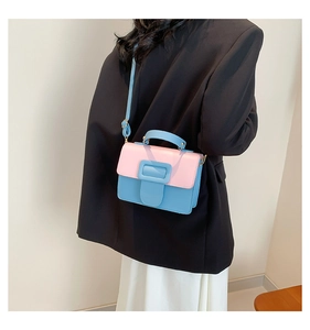 Chic pink and blue PU leather crossbody bag shown on model with adjustable strap and top handle