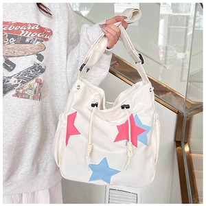 Dettaglio borsa a tracolla in nylon con toppe a stella colorate e chiusura a coulisse
