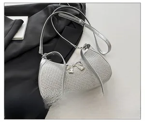 Detail of silver rhinestone crescent bag with metallic bow and adjustable leather strap