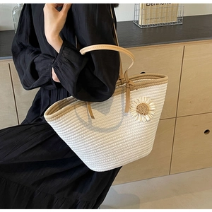 Close-up detail of a hand-woven tote bag with 3D daisy flower and thin leather straps