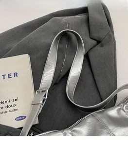 Detail of adjustable strap on silver metallic PU leather crossbody bag with quilted texture