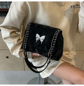 Détail du sac cabas plissé noir avec boucle papillon en métal liquide argenté
