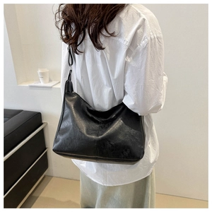 Detail of a chic black PU leather hobo bag with a natural wrinkled texture and zipper