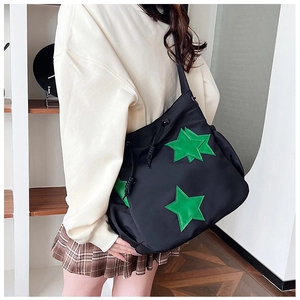 Dettaglio della borsa tote in nylon nero con stella verde e chiusura a coulisse