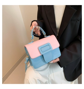 Detail of stylish blue and pink PU crossbody bag with wide buckle and top handle