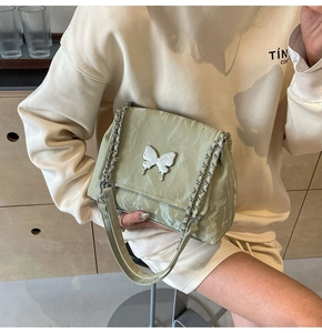 Détail du sac cabas vert sauge avec texture plissée et boucle papillon argentée