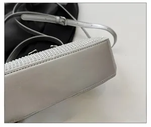 Detailed close-up of silver crossbody bag featuring rows of sparkling rhinestones and metal buckle