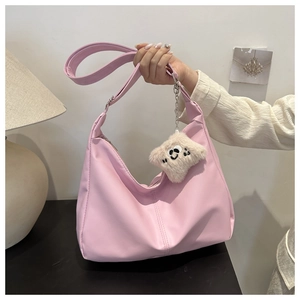 Close-up of pink PU leather half-moon shoulder bag with plush smiley face charm