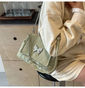 Vue détaillée du sac bandoulière en cuir PU vert sauge avec boucle papillon argentée