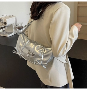 Close-up of a trendy silver metallic PU leather shoulder bag with stylish bow details
