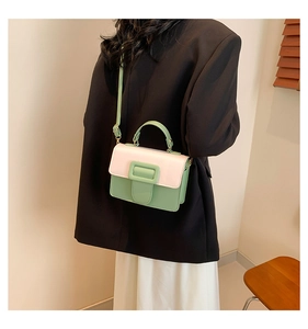 Detailed view of mint green and cream PU leather crossbody bag worn by a model