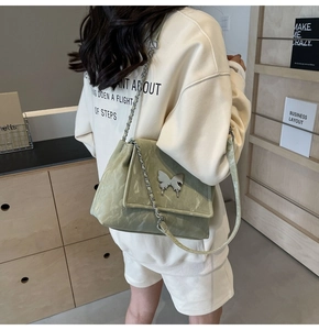 Détail du sac cabas vert clair en PU avec boucle papillon argentée et chaîne