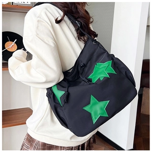 Dettaglio della borsa a tracolla in nylon nero con tre stelle verdi e chiusura a coulisse