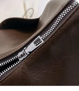 Detail view of brown soft leather shoulder bag showing smooth silver metal zipper and stitching