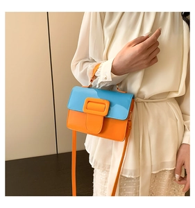 Detail of the blue and orange contrast PU leather handbag with a large square buckle