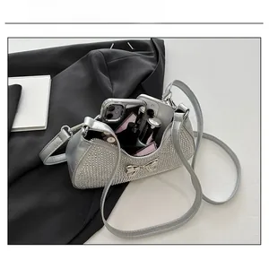 Silver crescent PU bag showing capacity for smartphone and lipstick with metal bow detail