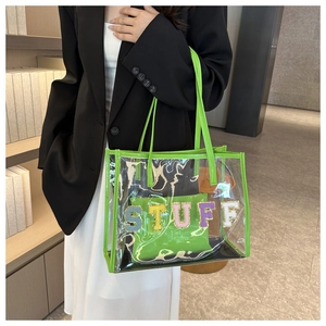 Detail of neon green trim on transparent PVC tote bag with STUFF textured lettering