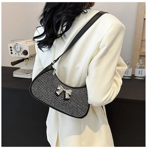Detail of black crescent moon bag featuring silver rhinestones and a metal bow accent