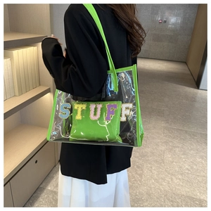 Detail shot of the neon green transparent PVC bag with a sequined STUFF letter patch