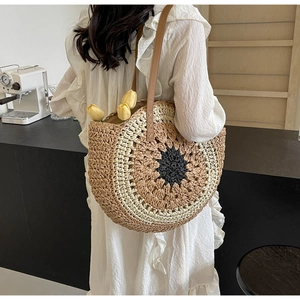 Detail of sunflower-style woven tote bag featuring contrast colors and leather straps