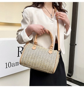 Détail du sac boston en paille tressée avec poignées en cuir PU et bandoulière