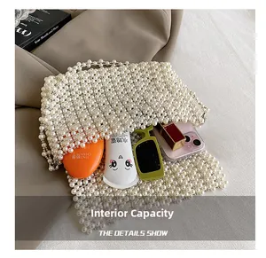 Internal capacity of pearl woven handbag showing space for phone, sunglasses and cosmetics