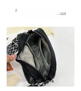Détail du petit sac carré avec intérieur à trois couches et bandoulière large