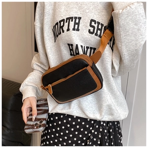 Detail of cross-body bag featuring lychee texture faux leather and adjustable buckle strap