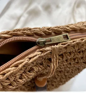 Detaillierte Makroansicht des glatten Bronze-Reißverschlusses und der Webstruktur der Tasche