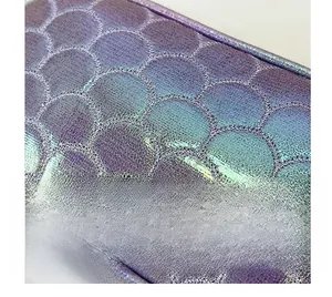 Detail of quilted iridescent PU leather crossbody bag with purple fish scale stitching