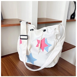 Borsa a tracolla in nylon bianco con stampa a stella colorata e tracolla regolabile su tavolo