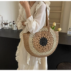 Bohemian woven straw sunflower tote bag worn by a model in a cozy cafe setting
