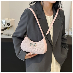 Close-up of pink crescent shoulder bag with sparkling rhinestones and silver bow