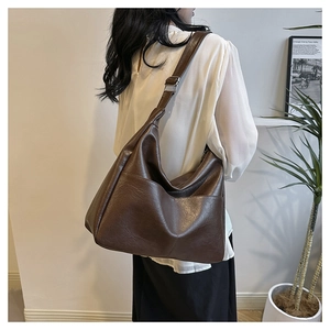 Detail of vintage brown soft leather bag with wide strap and silver metal buckle