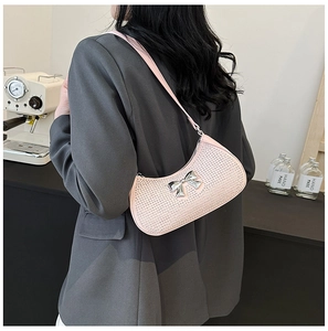 Close-up of pink rhinestone shoulder bag with silver bow buckle and leather strap