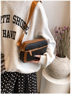 Detail of multi-compartment PU leather crossbody bag with brown wide nylon shoulder strap