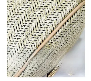 Détail d'un sac à main en paille tissée avec motifs noir et beige et bordure en cuir de qualité