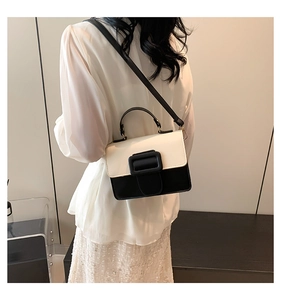 Detailed back view of a black and white contrast PU leather shoulder bag on a model