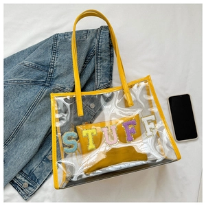 Transparent PVC tote bag with yellow interior pouch and colorful STUFF chenille letter patches