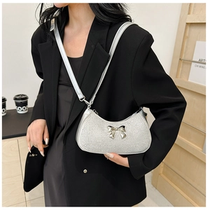 Silver rhinestone crescent shoulder bag with a metal bow detail on a black blazer