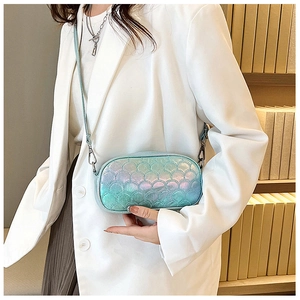 Detail of holographic cross body bag with fish scale quilting on glossy PU leather material